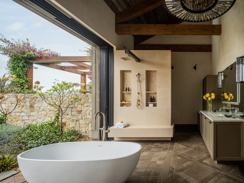 a spa like bathroom with soaking tub, open shower, and large sliding outside door